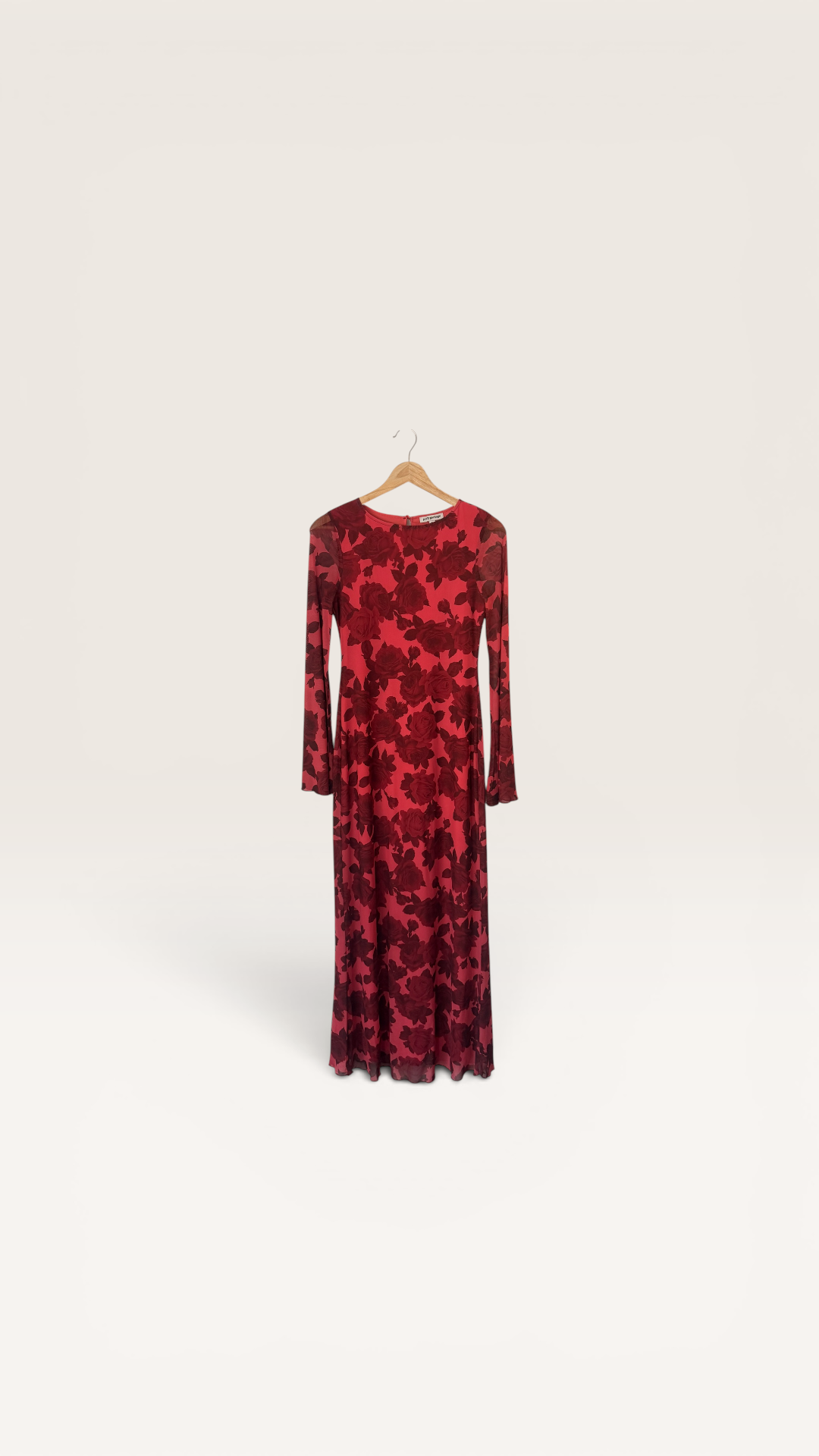 The Runway Reserve Pretty Garbage red floral mesh long sleeve maxi dress with crew neck hanging on a door.